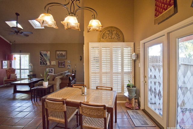 dining area featuring ceiling fan with notable chandelier and a skylight