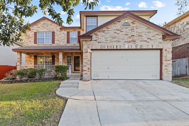 front of property featuring a front lawn, covered porch, and a garage