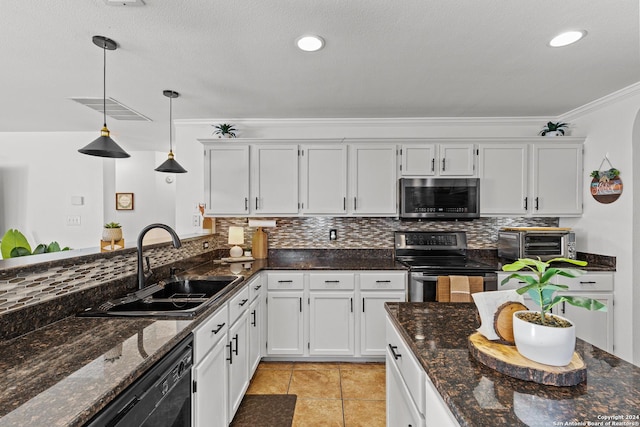 kitchen with white cabinets, pendant lighting, stainless steel appliances, and dark stone counters