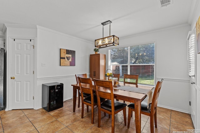 dining room with crown molding, light tile patterned floors, and beverage cooler