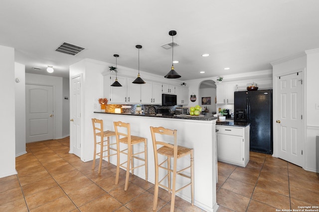 kitchen with backsplash, pendant lighting, a breakfast bar, white cabinets, and black appliances