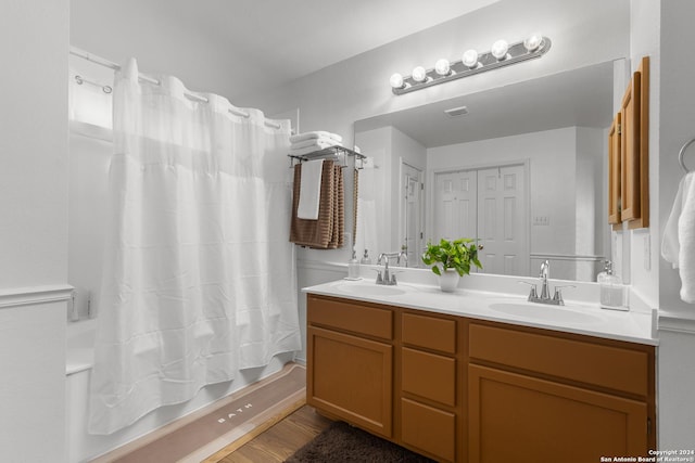 bathroom featuring hardwood / wood-style flooring, vanity, and shower / bath combo with shower curtain