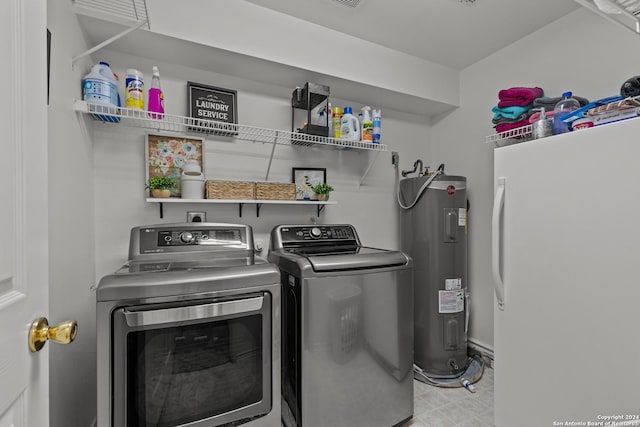 laundry area featuring electric water heater and separate washer and dryer