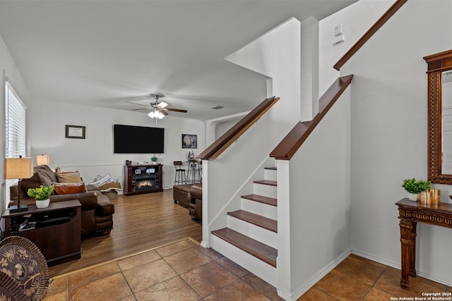 living room featuring ceiling fan and dark hardwood / wood-style flooring