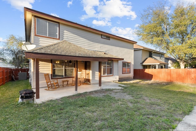 rear view of property with a lawn, a patio area, and a fire pit