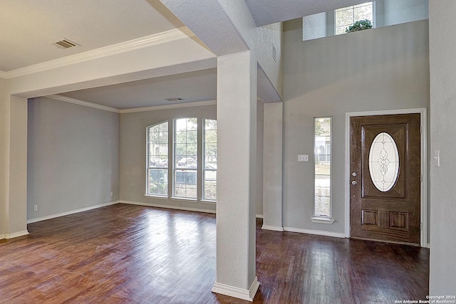 foyer entrance with dark hardwood / wood-style flooring, crown molding, and a wealth of natural light