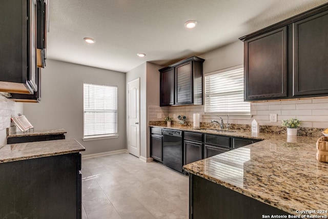 kitchen with sink, black dishwasher, tasteful backsplash, light stone counters, and dark brown cabinets