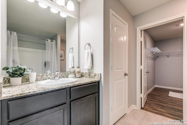 bathroom with hardwood / wood-style floors, vanity, and curtained shower