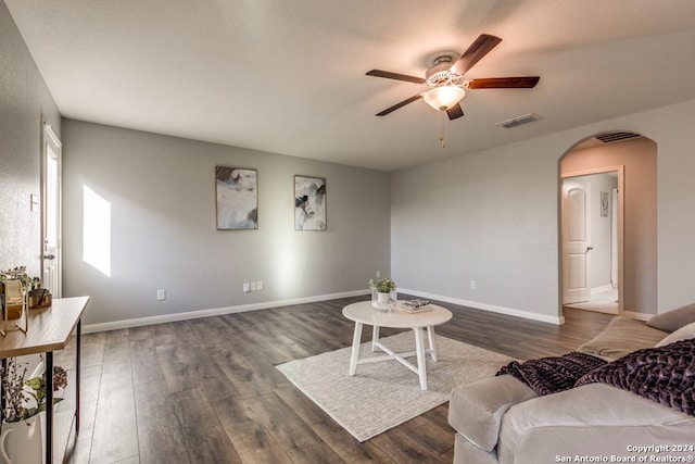 living room featuring ceiling fan and dark wood-type flooring