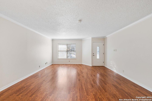 foyer entrance with a textured ceiling, wood-type flooring, and ornamental molding