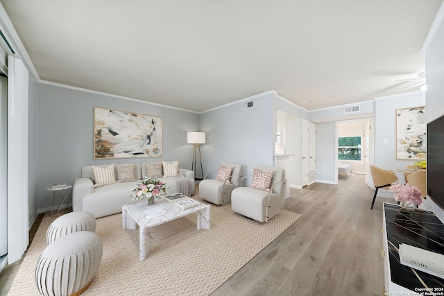 living room with light hardwood / wood-style floors and ornamental molding