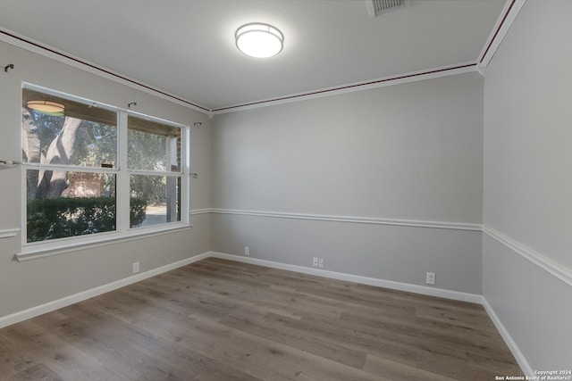 unfurnished room featuring crown molding and wood-type flooring