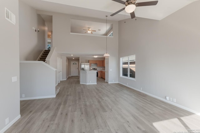 unfurnished living room featuring ceiling fan, high vaulted ceiling, and light hardwood / wood-style floors