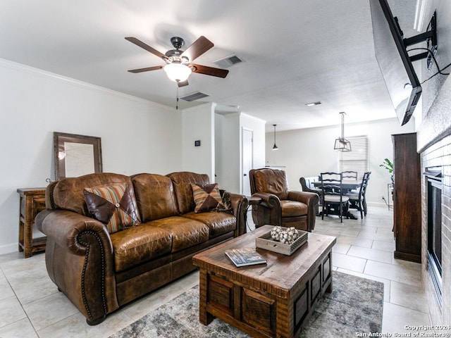 tiled living room featuring ceiling fan, a fireplace, and ornamental molding