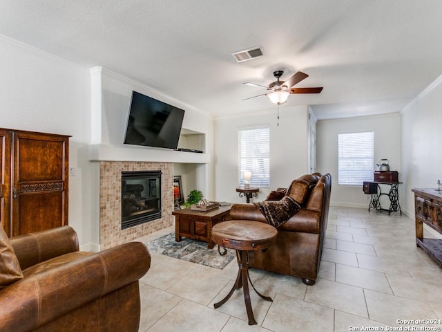 living room with ceiling fan, crown molding, and light tile patterned flooring