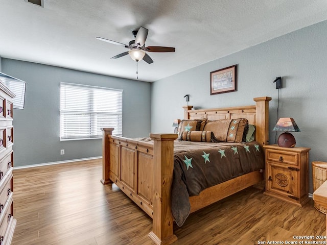 bedroom with ceiling fan, a textured ceiling, and light wood-type flooring