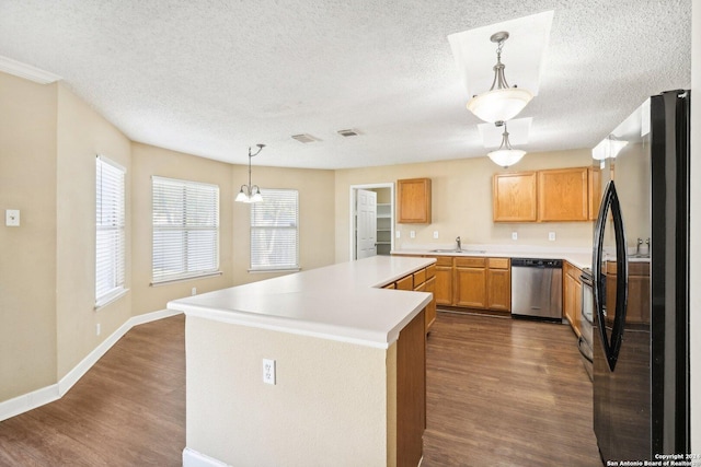 kitchen featuring black fridge, dishwasher, pendant lighting, and dark hardwood / wood-style floors