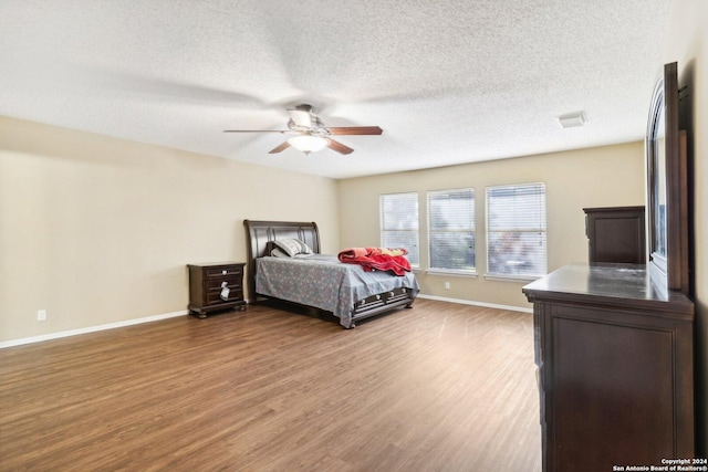 bedroom featuring hardwood / wood-style floors, a textured ceiling, and ceiling fan