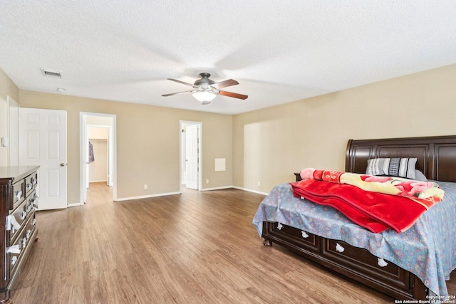 bedroom featuring a textured ceiling, light hardwood / wood-style flooring, and ceiling fan