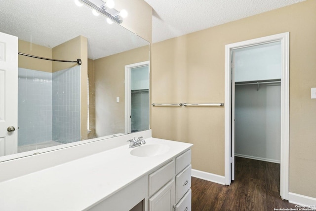 bathroom featuring a shower, vanity, a textured ceiling, and hardwood / wood-style flooring