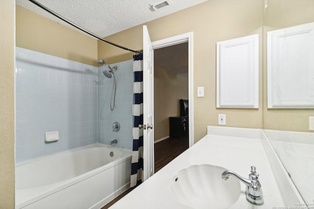 bathroom featuring vanity, shower / bath combination with curtain, a textured ceiling, and hardwood / wood-style flooring