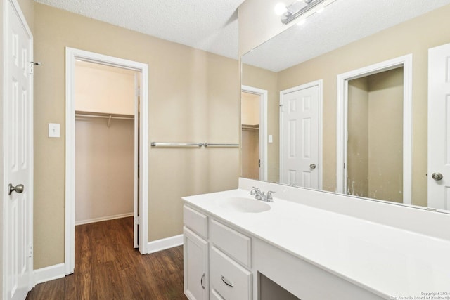 bathroom featuring hardwood / wood-style flooring, vanity, and a textured ceiling