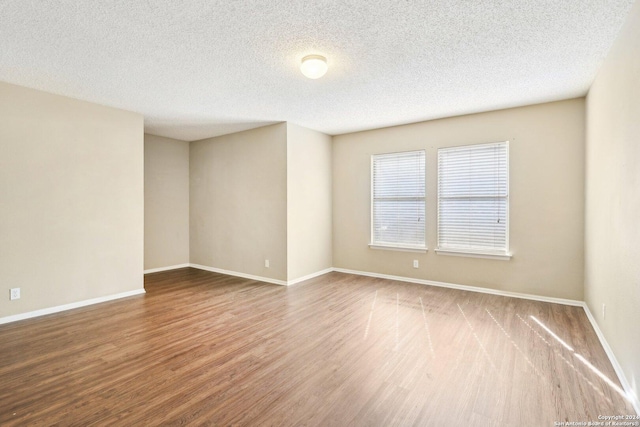 spare room featuring a textured ceiling and hardwood / wood-style flooring