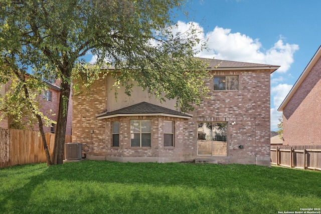 back of property with a lawn and cooling unit