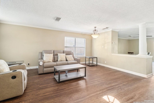 living room featuring decorative columns, dark hardwood / wood-style floors, and ornamental molding