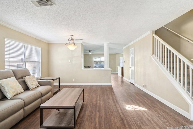 living room with a textured ceiling, crown molding, dark wood-type flooring, and a wealth of natural light