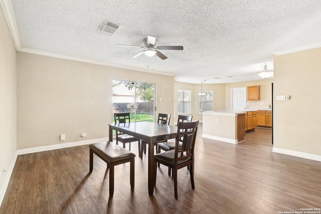 dining room with a textured ceiling, dark hardwood / wood-style flooring, ceiling fan, and crown molding