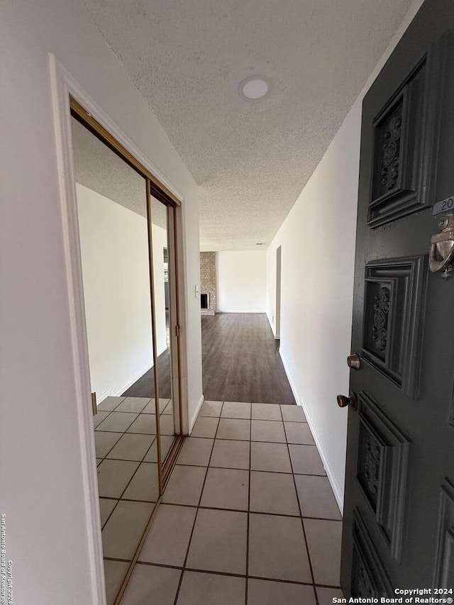 corridor featuring tile patterned floors and a textured ceiling