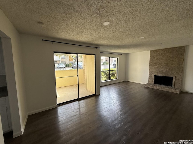 unfurnished living room featuring a textured ceiling, dark hardwood / wood-style floors, and a fireplace