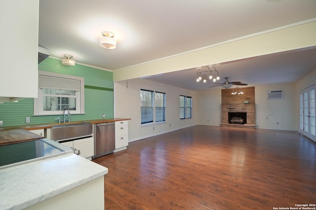 kitchen with ceiling fan, hanging light fixtures, stainless steel dishwasher, dark hardwood / wood-style floors, and white cabinets