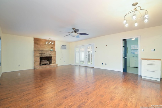 unfurnished living room with ceiling fan, a fireplace, dark wood-type flooring, and a wall mounted air conditioner