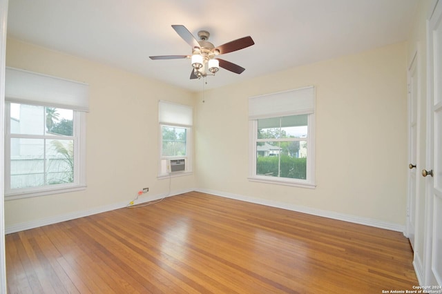 spare room with ceiling fan, cooling unit, and wood-type flooring