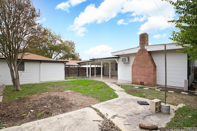 back of property featuring a wall mounted air conditioner and a carport