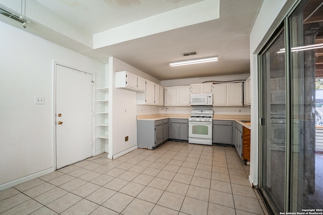 kitchen featuring gray cabinets, white cabinets, light tile patterned flooring, and white appliances