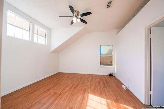 bonus room with ceiling fan, light hardwood / wood-style floors, and a textured ceiling