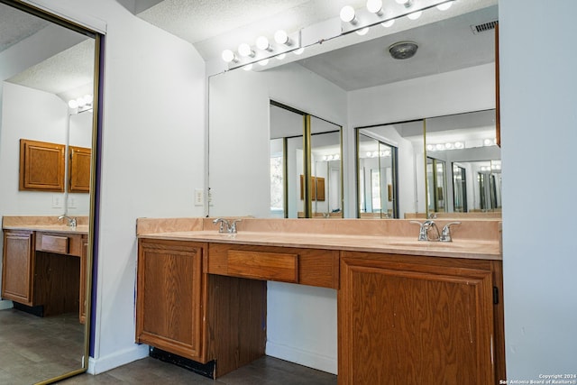 bathroom with vanity, a textured ceiling, and concrete floors