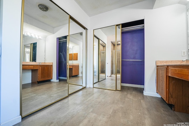 unfurnished bedroom with a textured ceiling and light hardwood / wood-style flooring