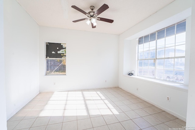 tiled spare room with a textured ceiling and ceiling fan