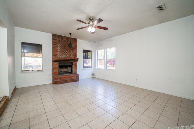 unfurnished living room featuring a wealth of natural light, a fireplace, and a textured ceiling