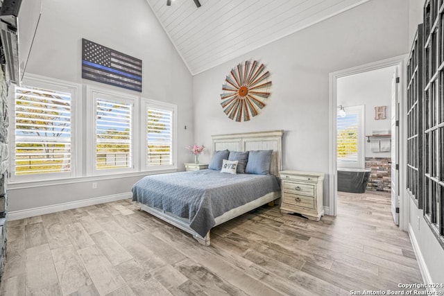 bedroom with high vaulted ceiling, wood ceiling, and light wood-type flooring