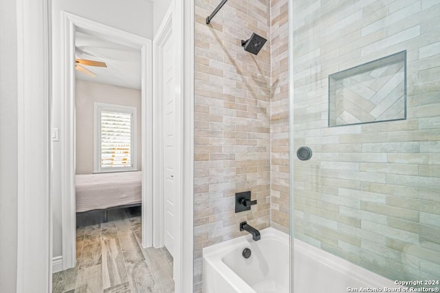 bathroom featuring wood-type flooring and tiled shower / bath