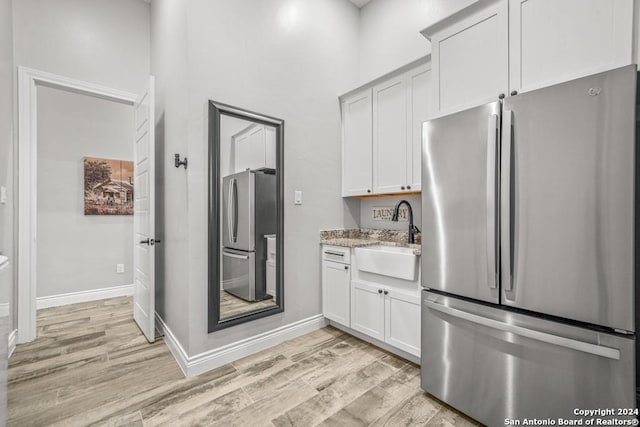 kitchen with white cabinets, stainless steel fridge, and sink