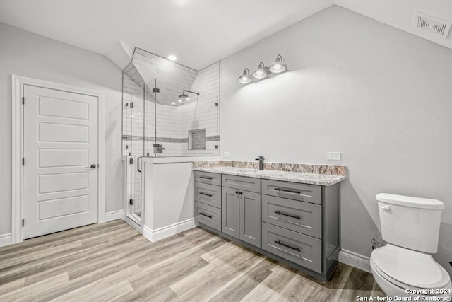 bathroom featuring hardwood / wood-style flooring, vanity, toilet, and a shower with shower door