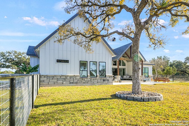 rear view of house with a lawn and a patio