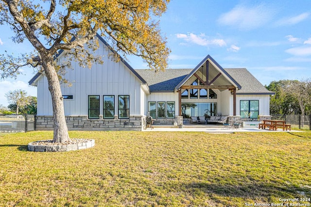 rear view of property featuring a lawn and a patio