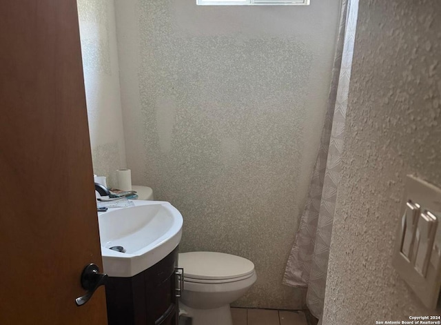 bathroom with tile patterned flooring, vanity, and toilet